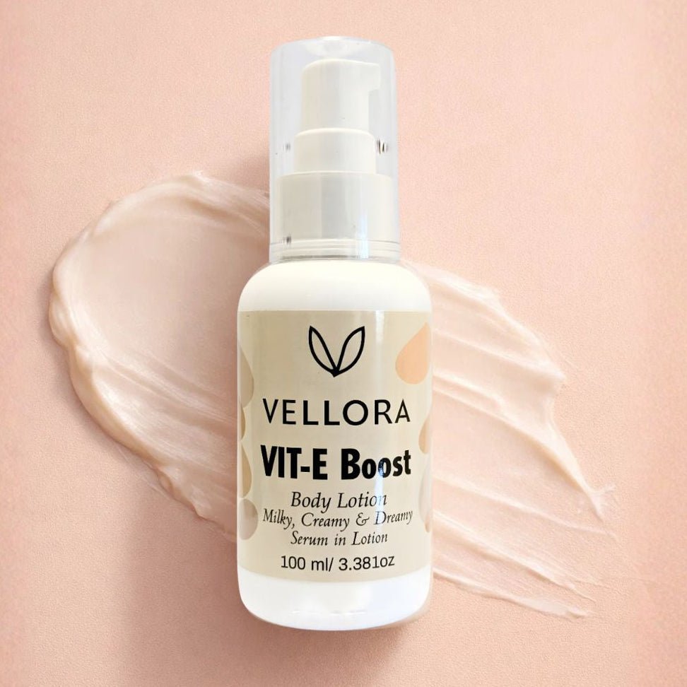 Vellora VIT-E Boost Body Lotion 100 ml with creamy texture smear, vitamin E enriched serum-in-lotion for deep hydration, nourishment and soft glowing skin for daily body care.