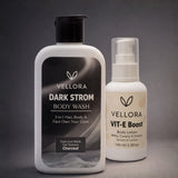 Vellora Dark Strom charcoal body wash paired with Vit-E Boost body lotion in water and liquid splash shot, highlighting deep cleansing, hydration, and smooth glowing skin