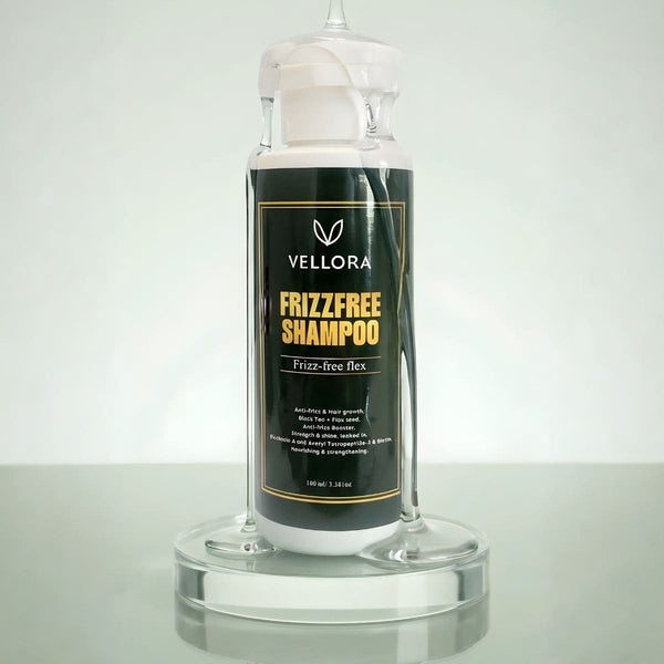 Vellora Frizz-Free Shampoo bottle on a clear stand, anti-frizz hair shampoo designed to smooth flyaways and add shine